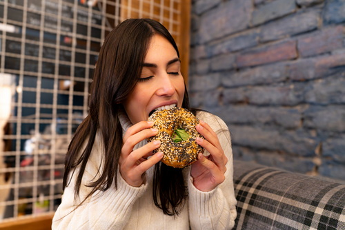 Woman biting a bagel